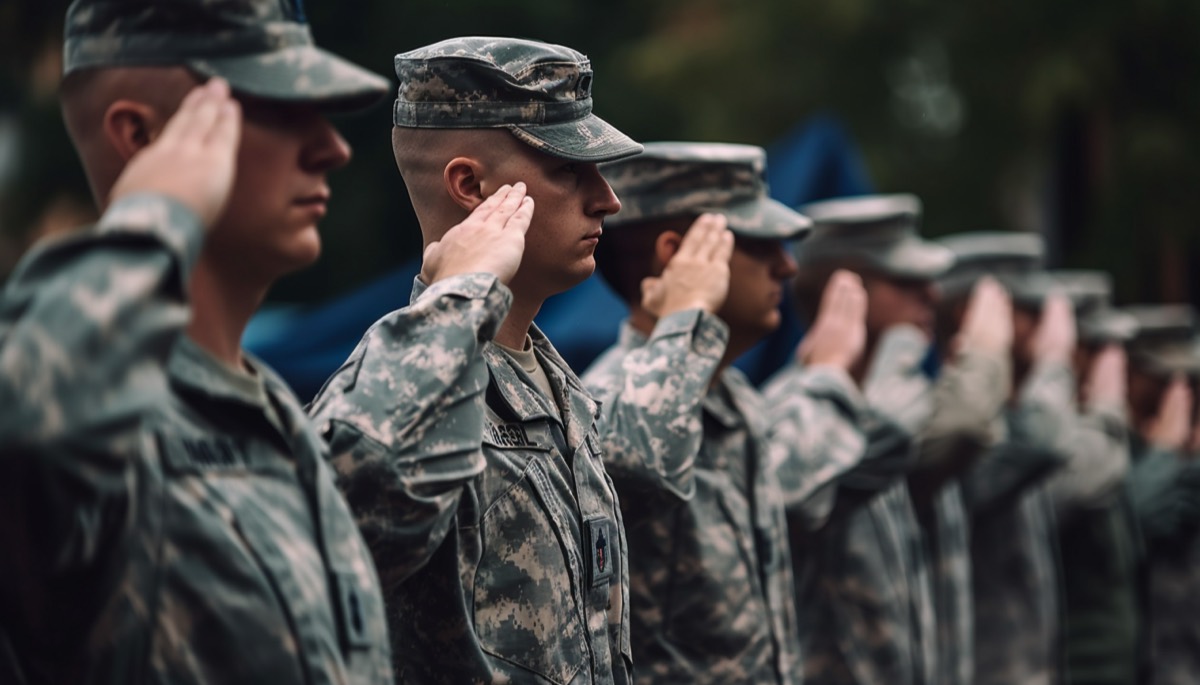 A row of soldiers in uniform saluting, honoring those who served